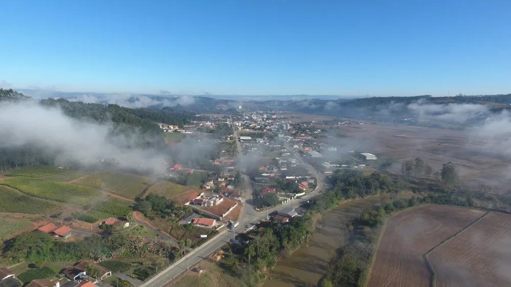 Vista aérea de Rio do Oeste, com neblina baixa sobre o vale e o centro ao fundo